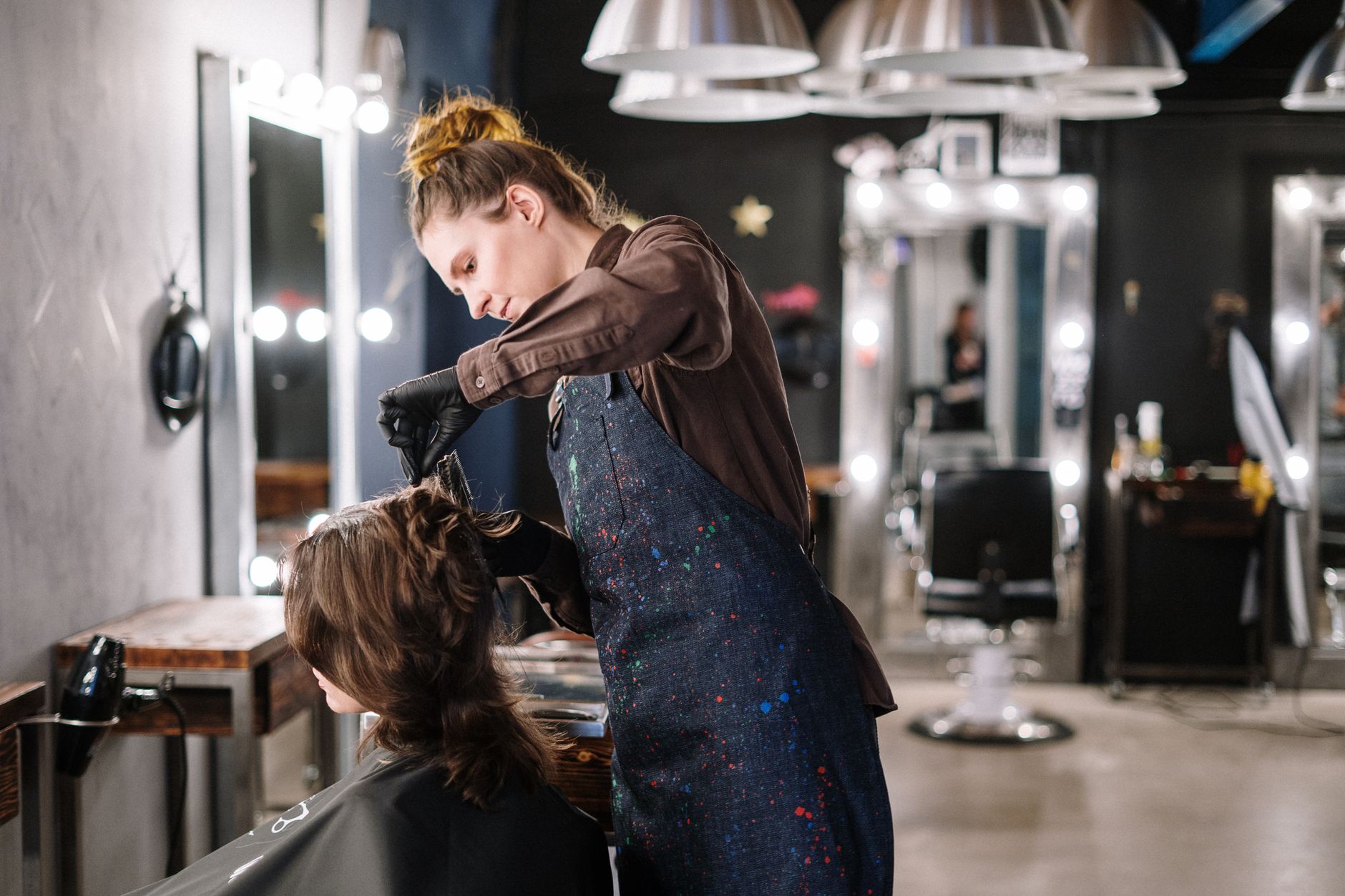 Hair stylist blow-drying a client's hair in a busy New Zealand salon