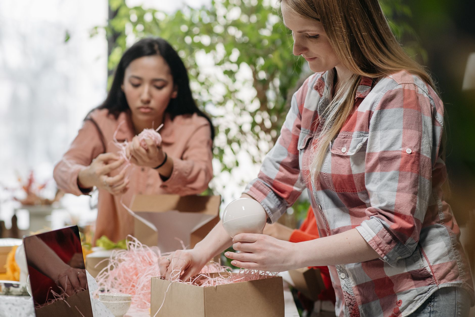 women packing orders into cardboard boxes