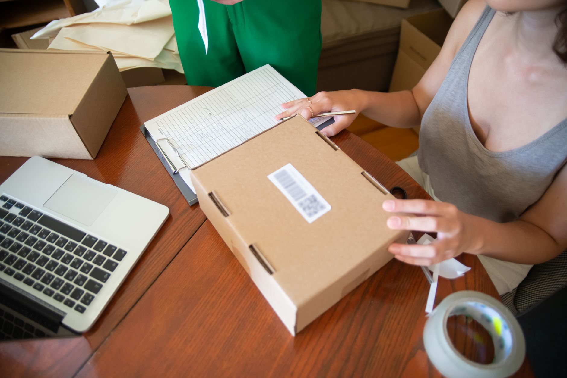 Etsy seller sitting at a table packing customer orders for shipping