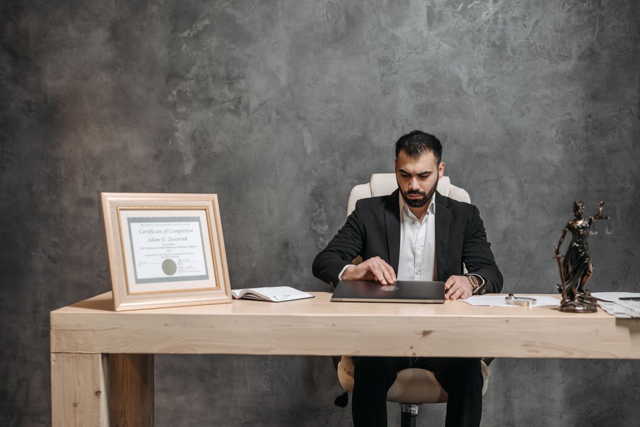 NZ lawyer working on a laptop at an office desk reviewing legal documents